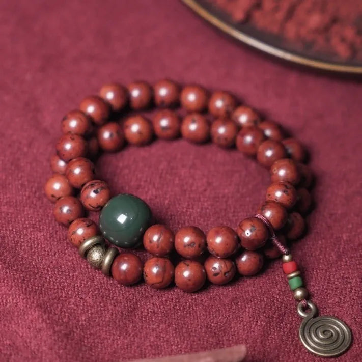 Handmade bodhi seed double circle bracelet with cartoon style on a wrist.