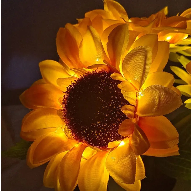 Sunflower LED night light with artificial flowers on wooden table
