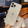 Transparent silicone iPhone case with a colourful laser love heart pattern on a table.