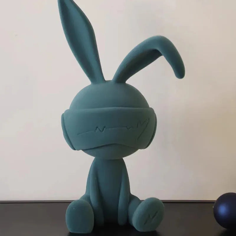 Small green resin suede blindfold rabbit table ornament on a wooden surface