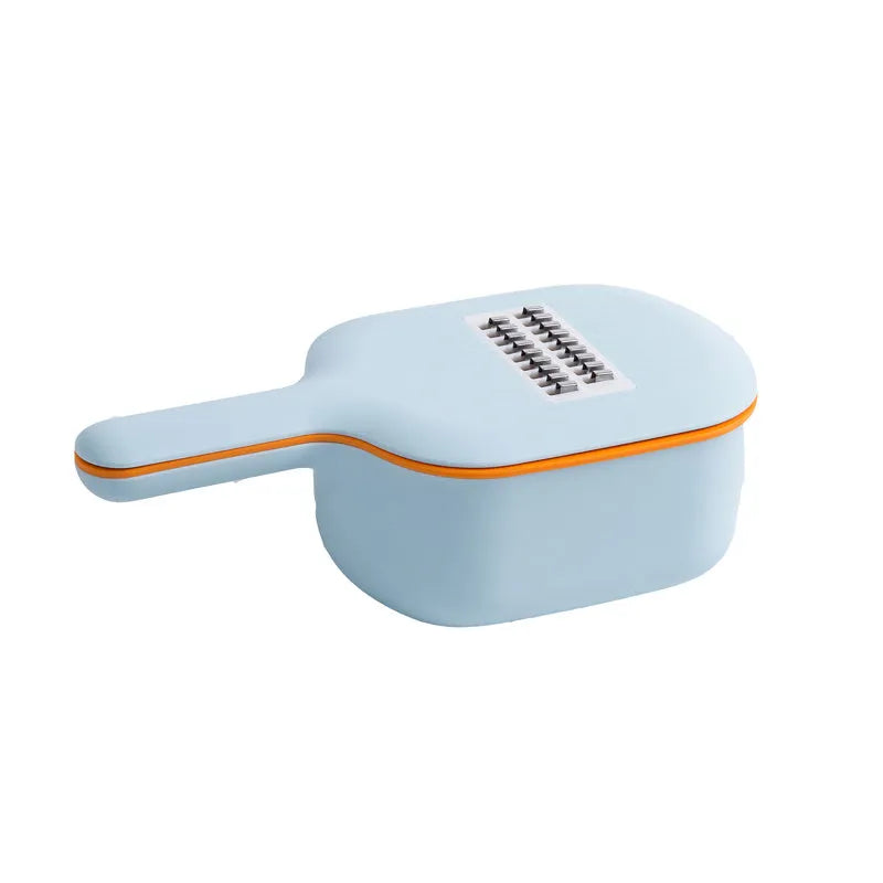 Dark blue vegetable cutter with four stainless steel blades, drain basket, and hand protection guard on kitchen counter