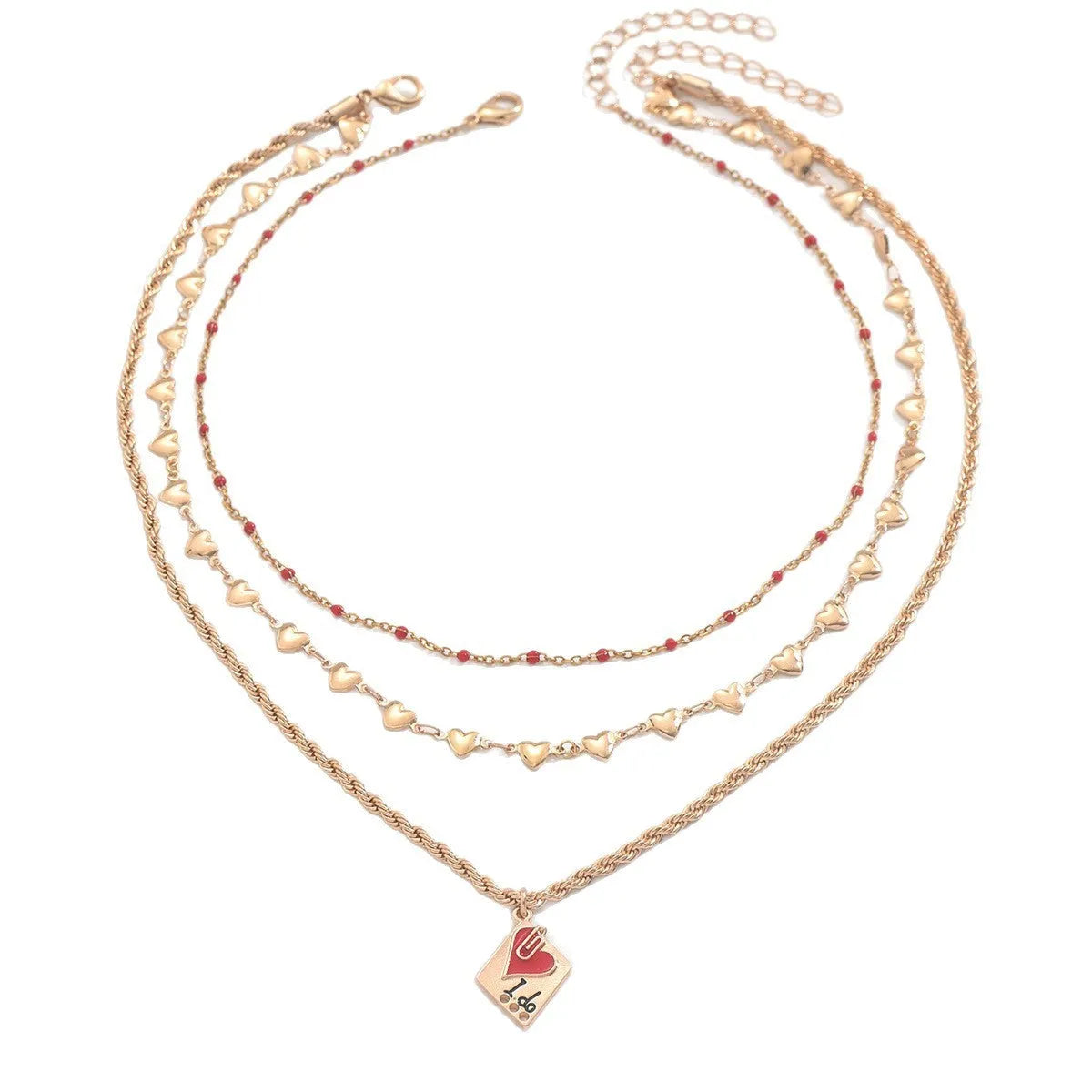 Close-up of a silver-toned three-layer necklace with small geometric heart pendants on an adjustable chain.
