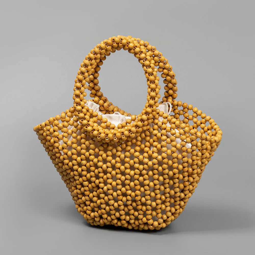 Hand-woven maple beach handbag with wooden beads in dumpling shape, shown in milky white colour