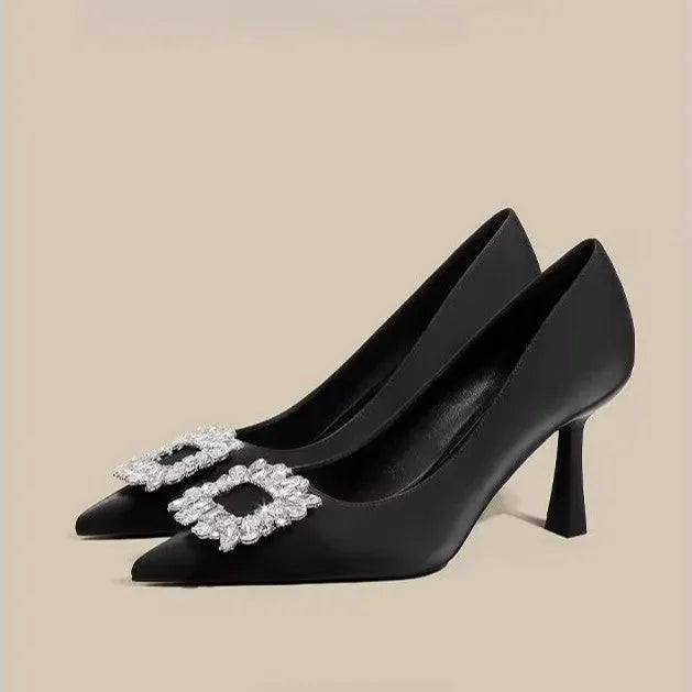 Women's creamy-white pointed toe stiletto pumps with a mid-height heel on a plain background.