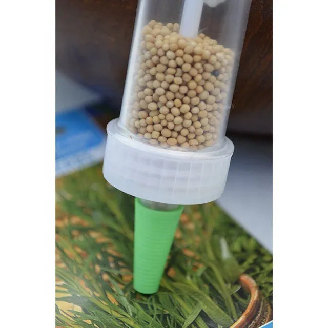 A 12cm long, 3cm diameter plastic mini garden seeder tool for dispensing seeds into pots.