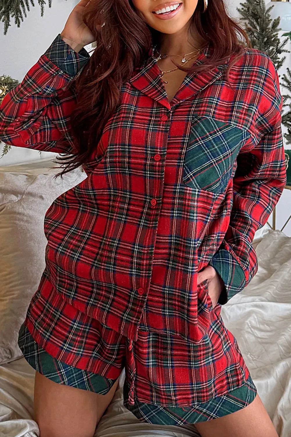 Red plaid Christmas pyjama set with long sleeve shirt and shorts on a hanger.