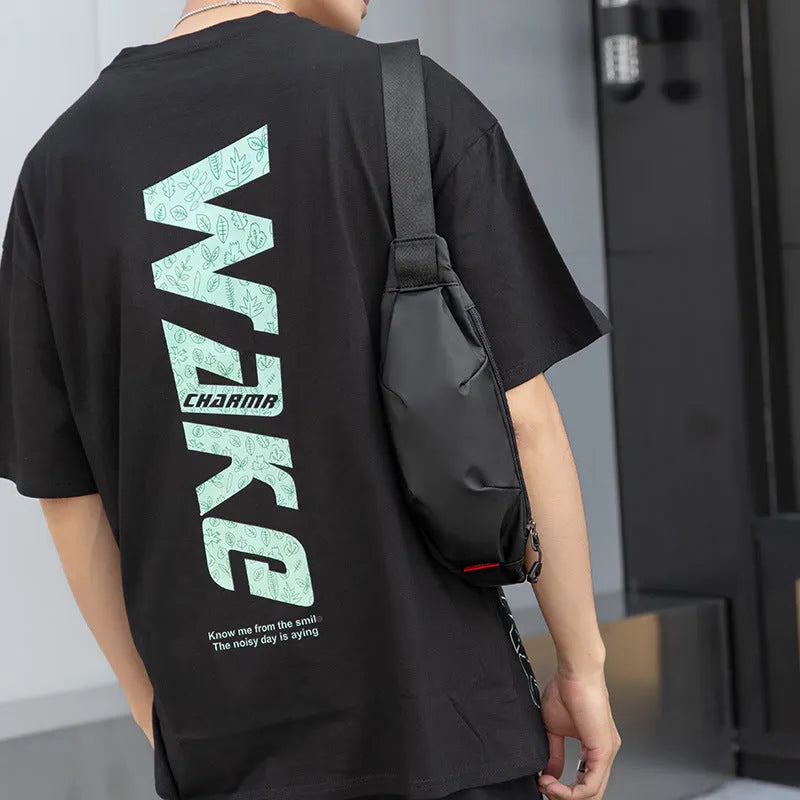 Black Oxford cloth men's crossbody waist pack showing front zipper and compact size.