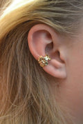 Women's gold starfish and conch shell drop earrings on a white background.