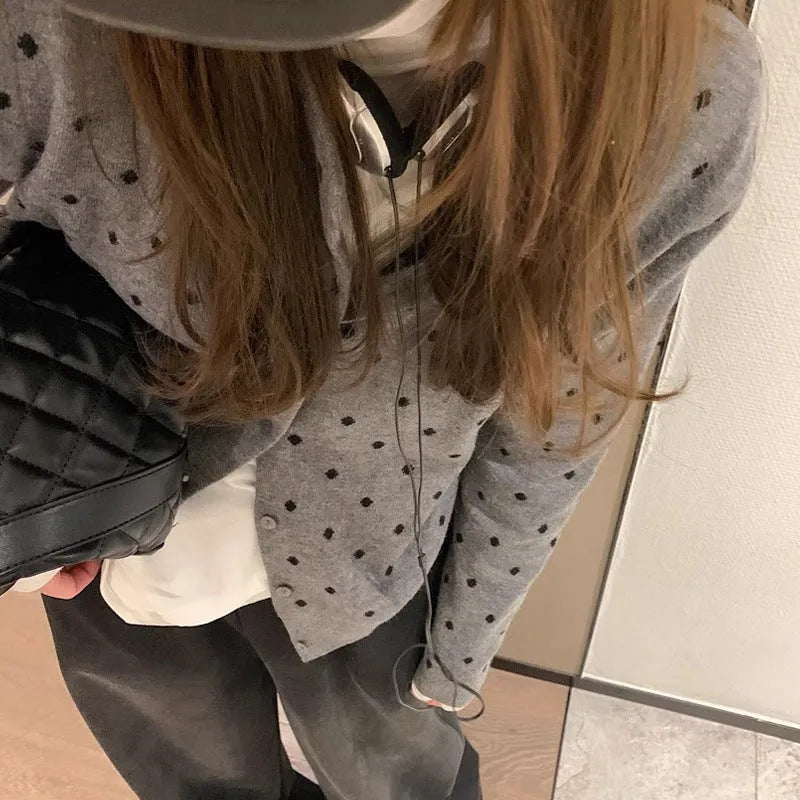 Women's grey and black Korean-style loose knit cardigan with crochet flower detail on the front.