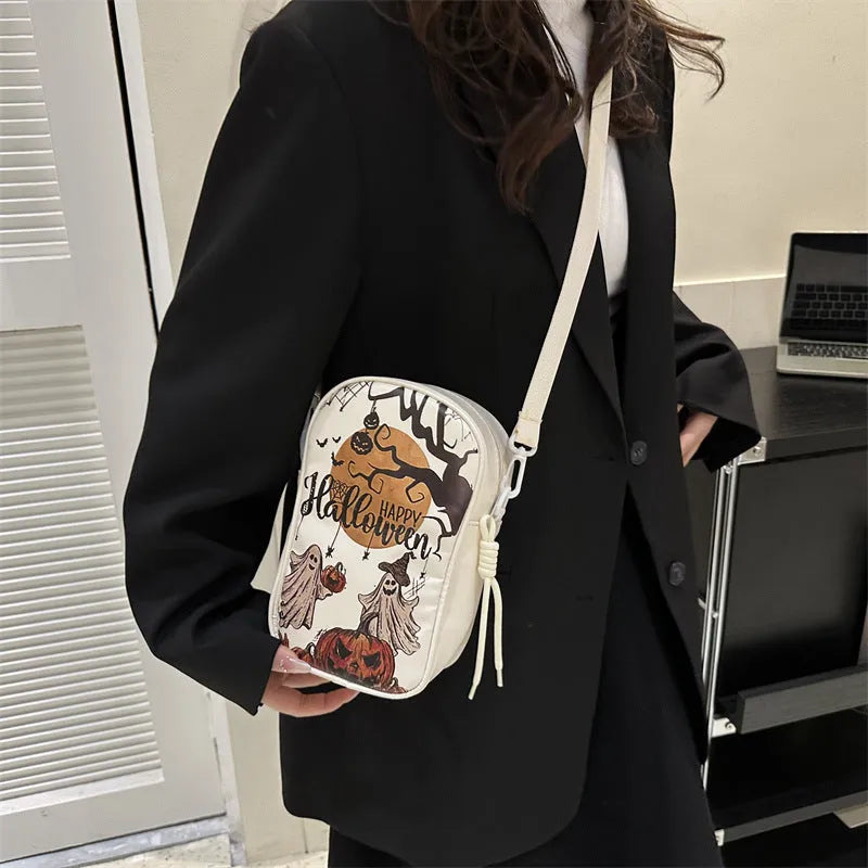 Women's black mini crossbody bag with orange Halloween pumpkin graffiti print.