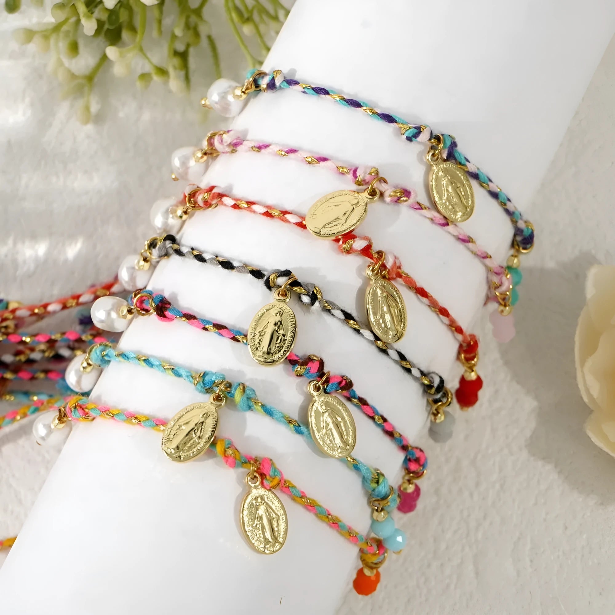 Close-up of a woman's hand-woven colourful braided rope bracelet in ethnic style, showing textured weave detail.
