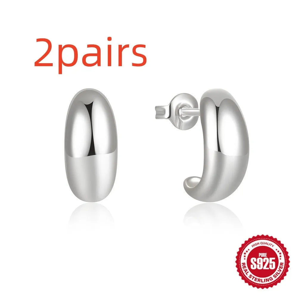 A single glossy C-shaped sterling silver stud earring on a white background.