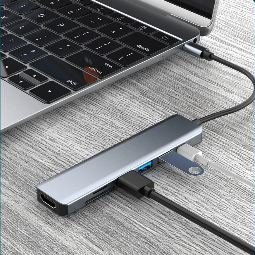 Seven-in-one USB C docking station expander hub with aluminium housing and multiple ports.