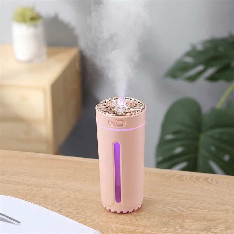 Black portable ultrasonic humidifier with colourful LED lights on a car cup holder.