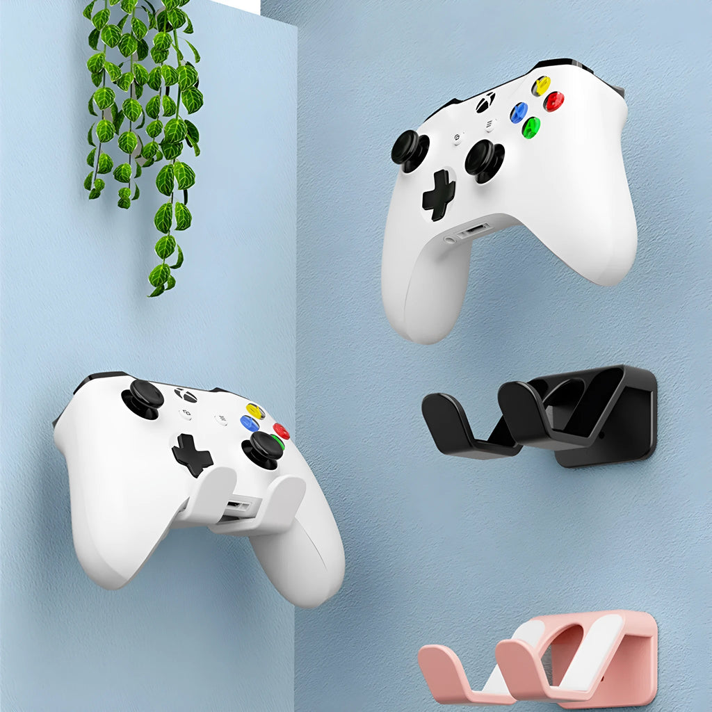 Universal black plastic hanging rack for game controllers mounted on a wall with adhesive.