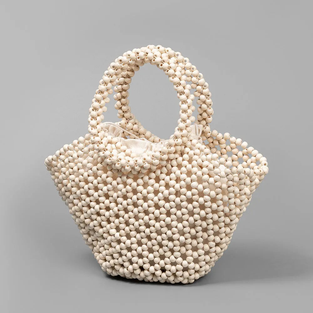 Hand-woven maple beach handbag with wooden beads in dumpling shape, shown in milky white colour