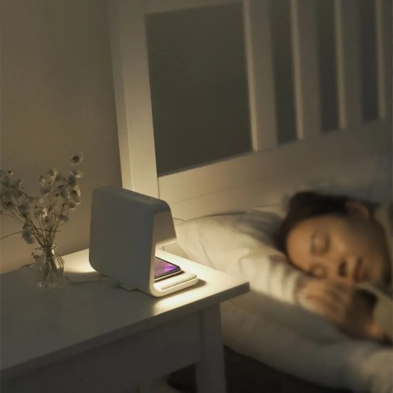 White 3-in-1 bedside lamp with wireless charging pad, LCD clock screen, and fabric-effect ABS shade.