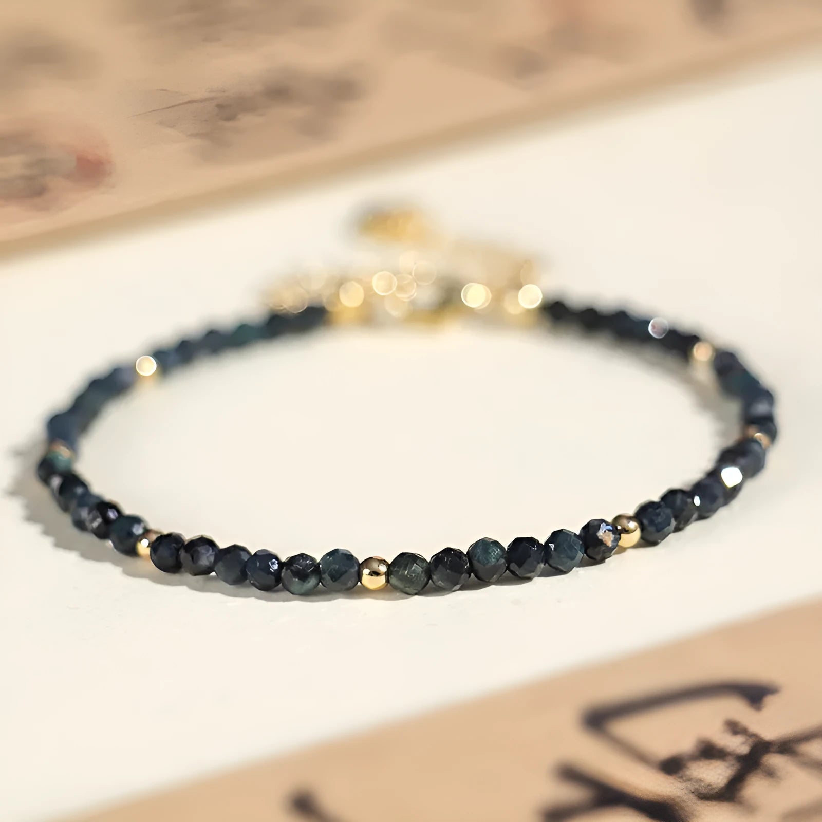 Blue tourmaline gemstone bracelet with 3mm beads and gold spacer details.