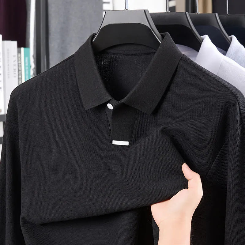 Man wearing a loose grey cotton polo shirt with a lapel collar and asymmetric design detail.
