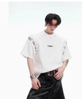 Deconstruction style short sleeve T-shirt with lace-up sides and cutout details in black or white.