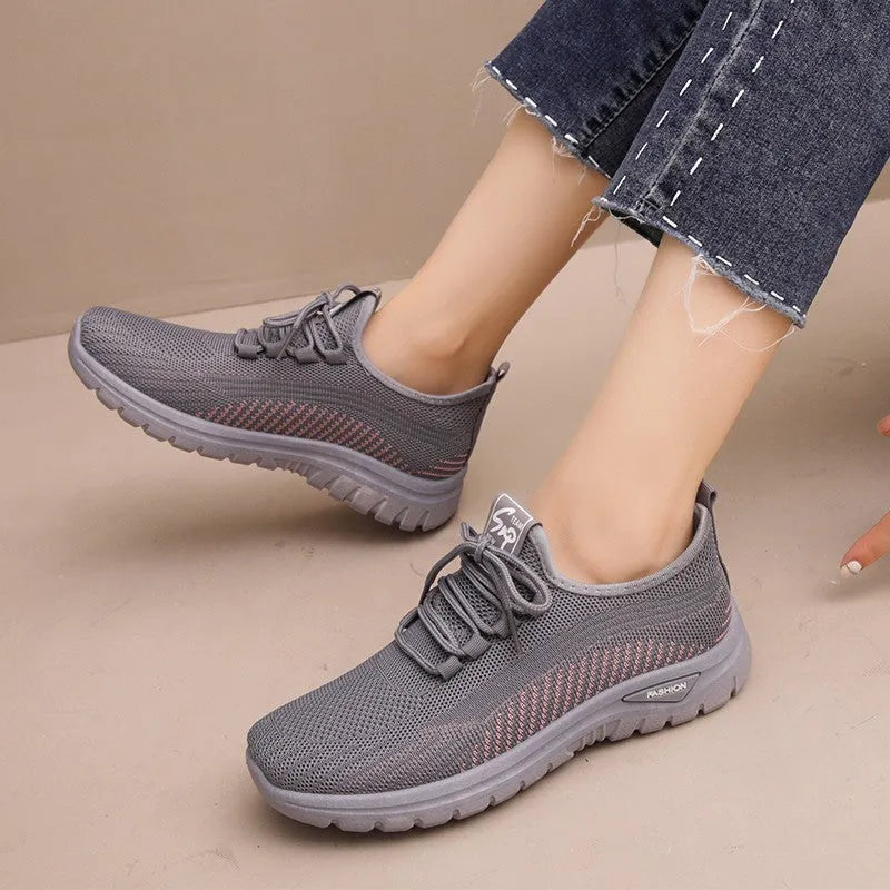 Women's black mesh sneakers with cross straps, round toe, and lace-up front on a rubber sole.