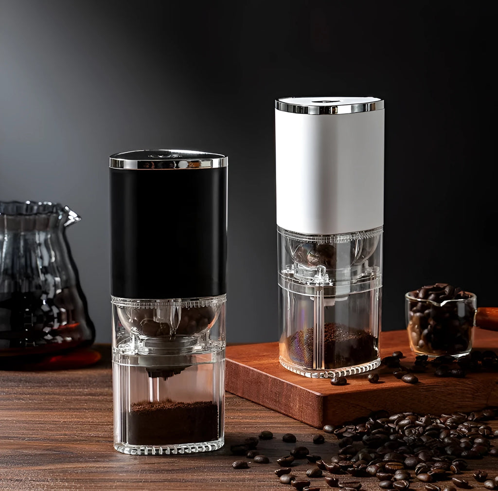 White portable electric coffee grinder with USB charging cable on a wooden table