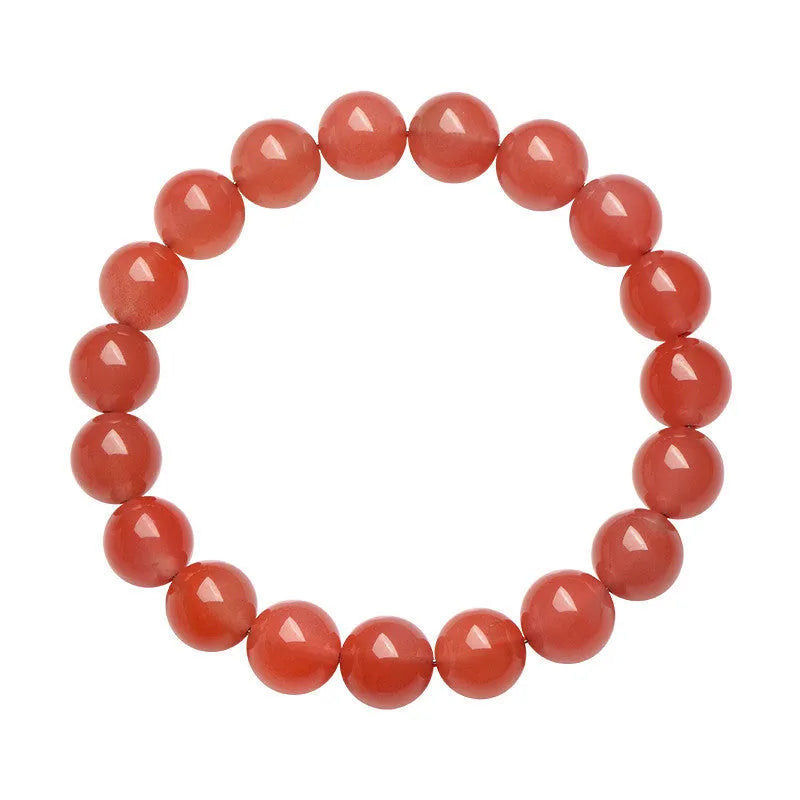 Natural cherry red agate bracelet with polished beads in a scattered design on a wrist.