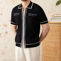 A black lapel short-sleeved knit polo shirt laid flat, showing the collar and slim fit.