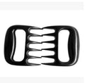 Two black bear claw-shaped meat shredding forks with patterned handles on a kitchen surface.