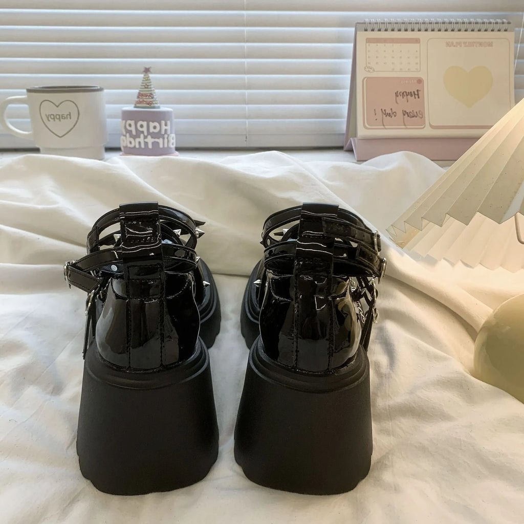 Black patent leather bat cosplay Lolita shoes with metal chain buckle and chunky heel on white background