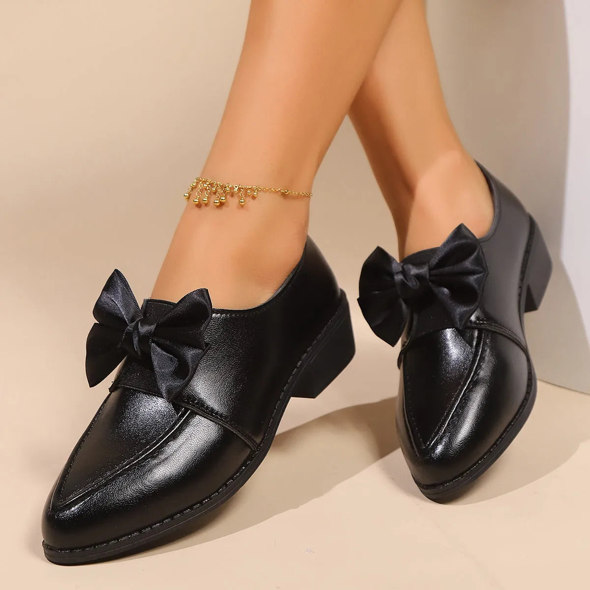 Women's simple slip-on shoe in a British-style leather look with a choice of buckle or bow decoration on the upper.