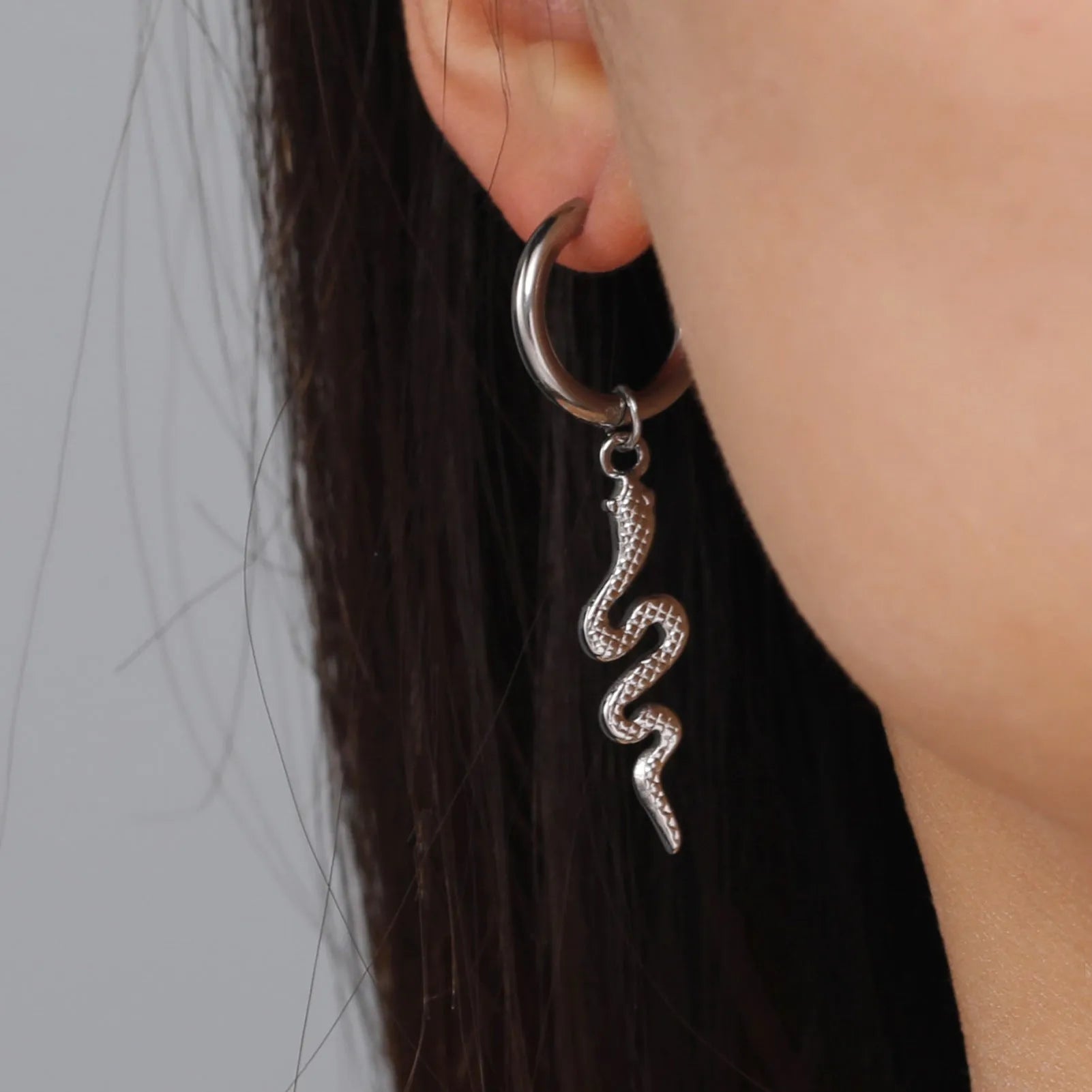 A pair of vintage-style snake-shaped earrings in stainless steel with a gold or steel electroplated finish.