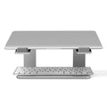 Black aluminium laptop stand with angled platform on a wooden desk