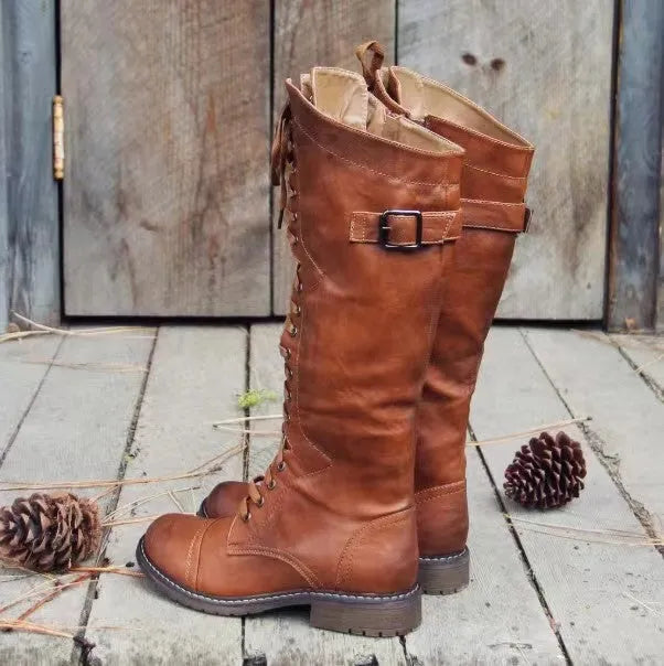 Women's black chunky heel high leg boots with a round toe and low heel on a plain background.