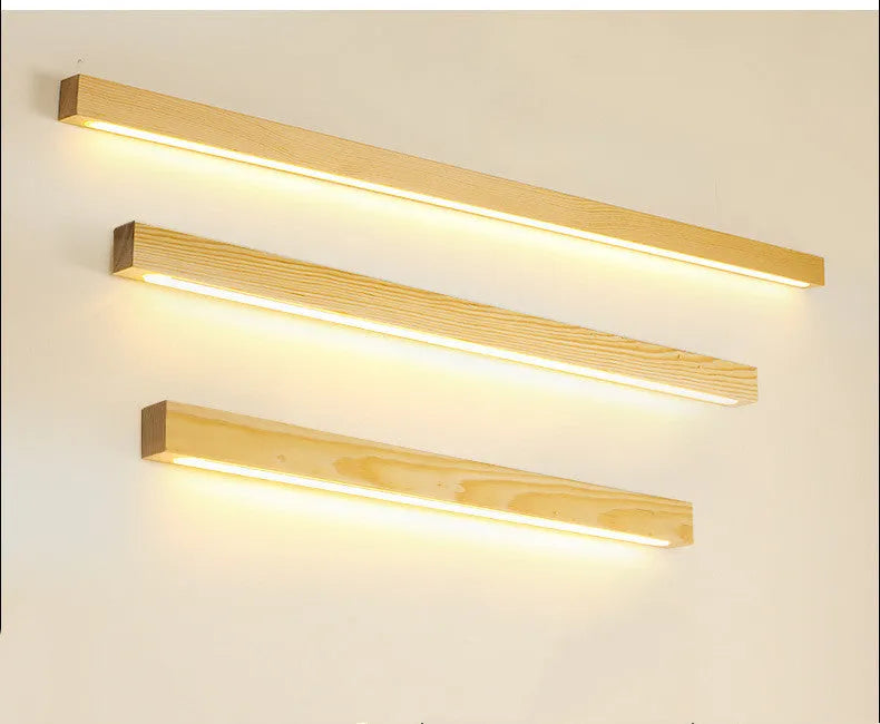 Walnut-coloured wooden log strip LED wall lamp with acrylic diffuser in minimalist design.