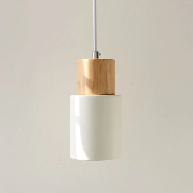 Nordic style solid wood and iron pendant light hanging above a kitchen counter.