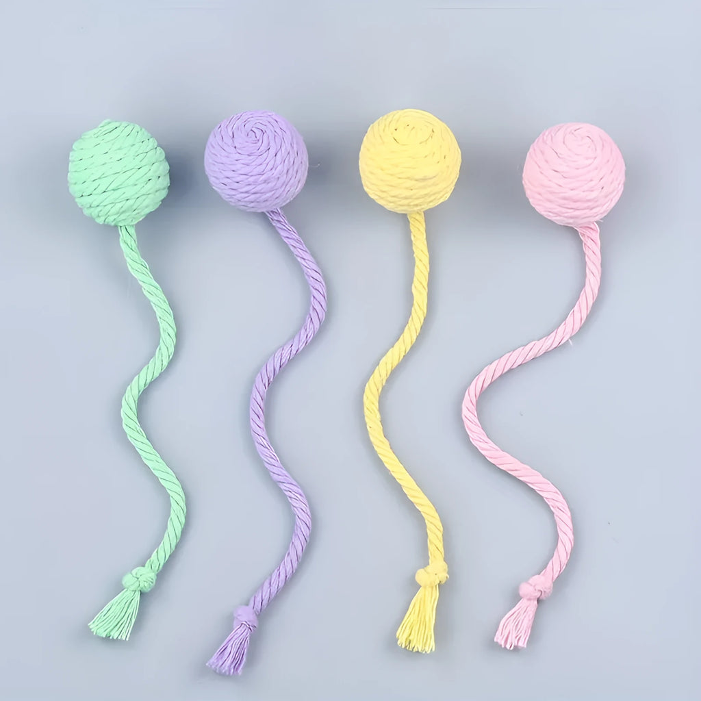 Cat toy ball with integrated rope and bell in green pink purple yellow colours
