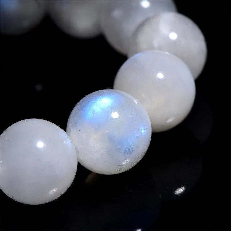Natural blue moonlight polished moonstone round bead bracelet on wrist.
