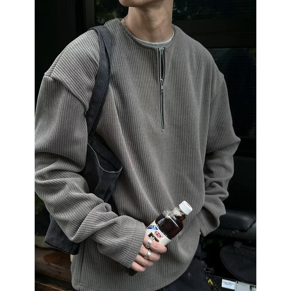 A grey loose-fitting long sleeve women's pullover top hanging flat.
