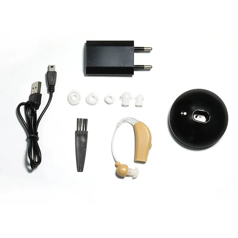 Black silicone rechargeable hearing aid amplifier for elderly users on a charging cable.