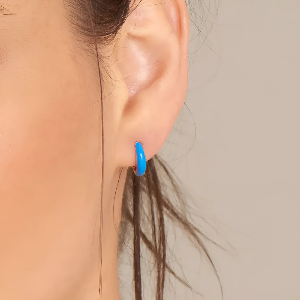 Pair of curved oval epoxy earrings in geometric ring design on a U-shaped hook.