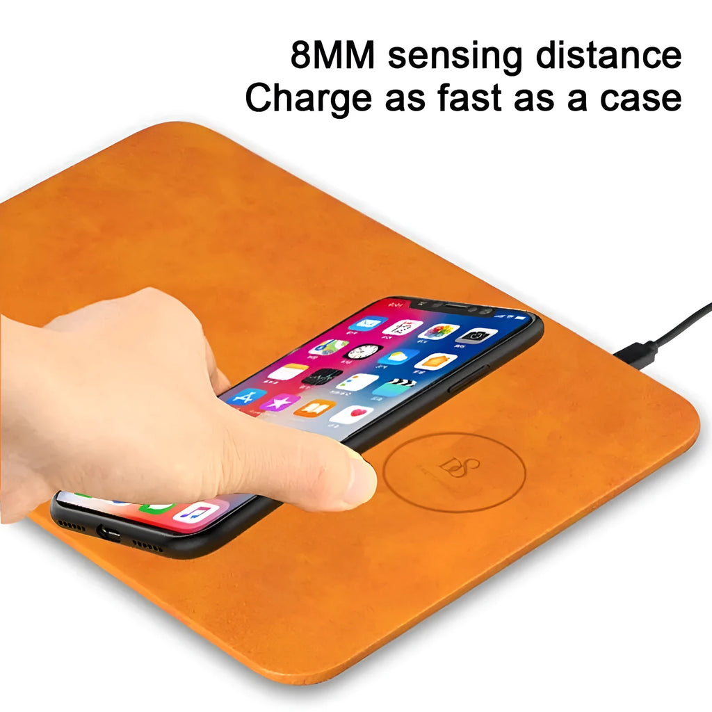 Brown leather wireless charging mouse pad with Micro USB cable on a wooden desk.