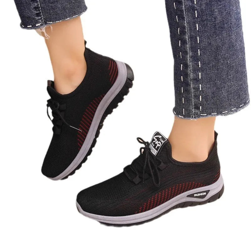 Women's black mesh sneakers with cross straps, round toe, and lace-up front on a rubber sole.
