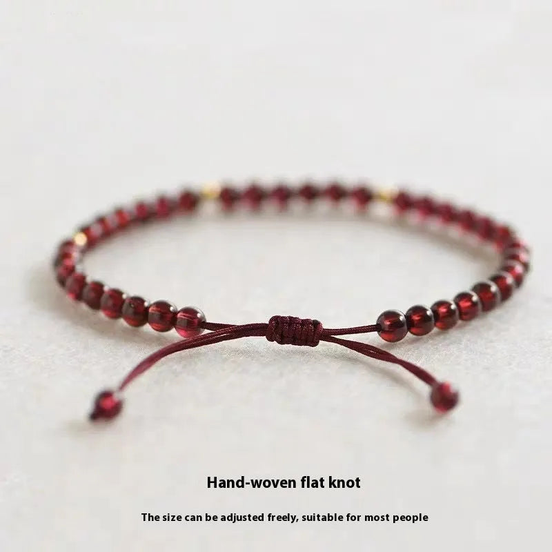 Hand-woven red rope garnet bracelet on a wrist, showing flexible wire and new Chinese style.