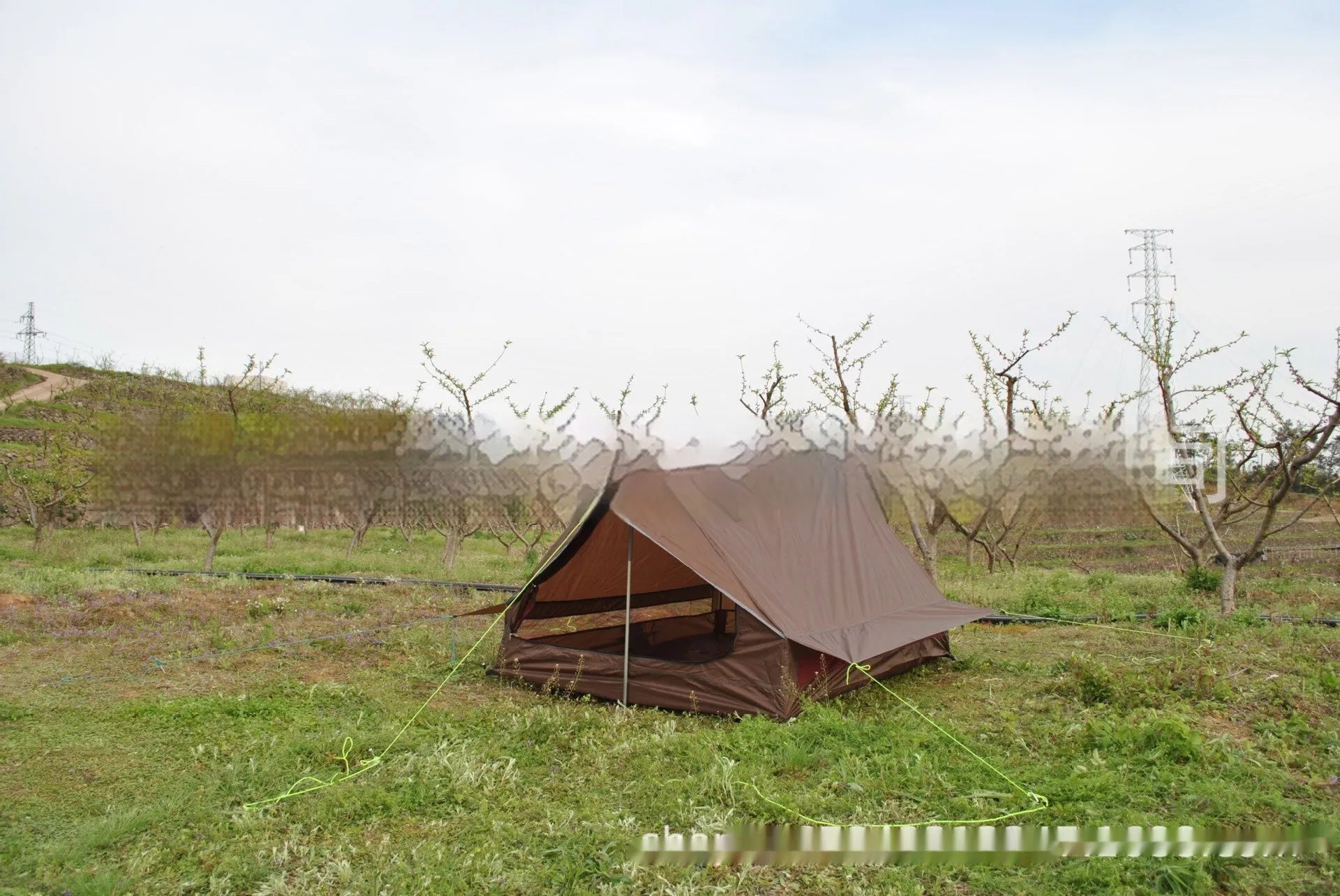 Brown A-line pole-free cabin tent pitched with hiking canes showing spacious interior dimensions