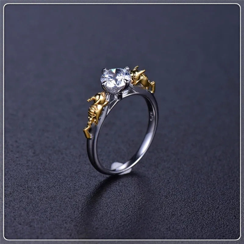 Black gold crystal crown ring on a finger, showing copper metal and decorative stones.