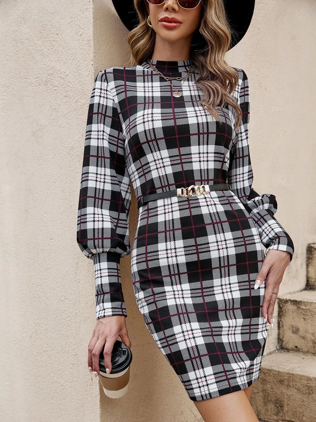 Black tight dress with lantern sleeves and leather stitching details, mid-length silhouette.