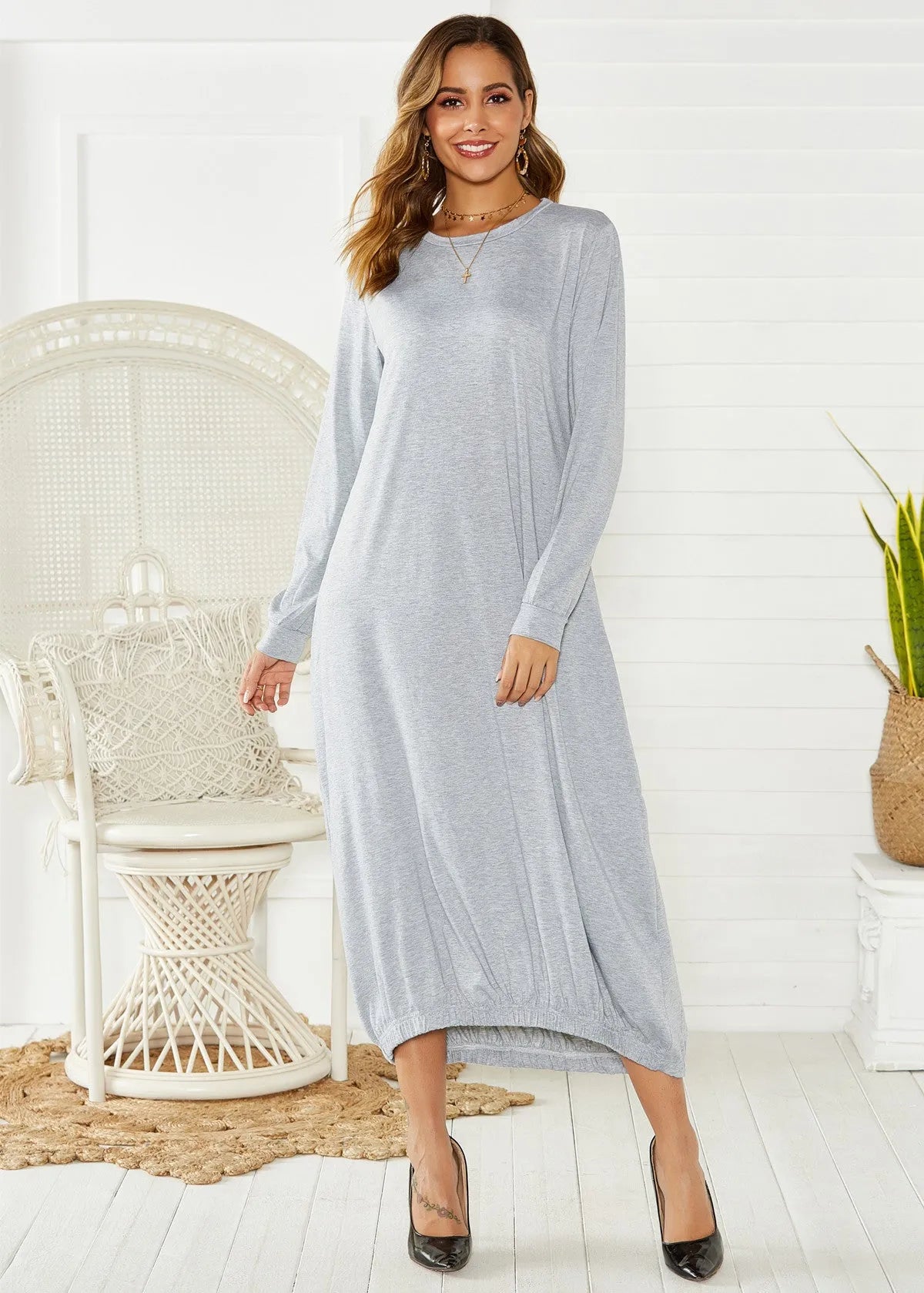 A loose, long black lantern dress with a lace-up crew neck on a mannequin.