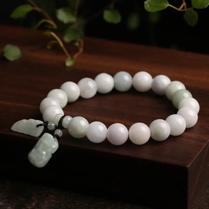 Green jade beaded bracelet with a hanging Maitreya Buddha charm on a wrist.