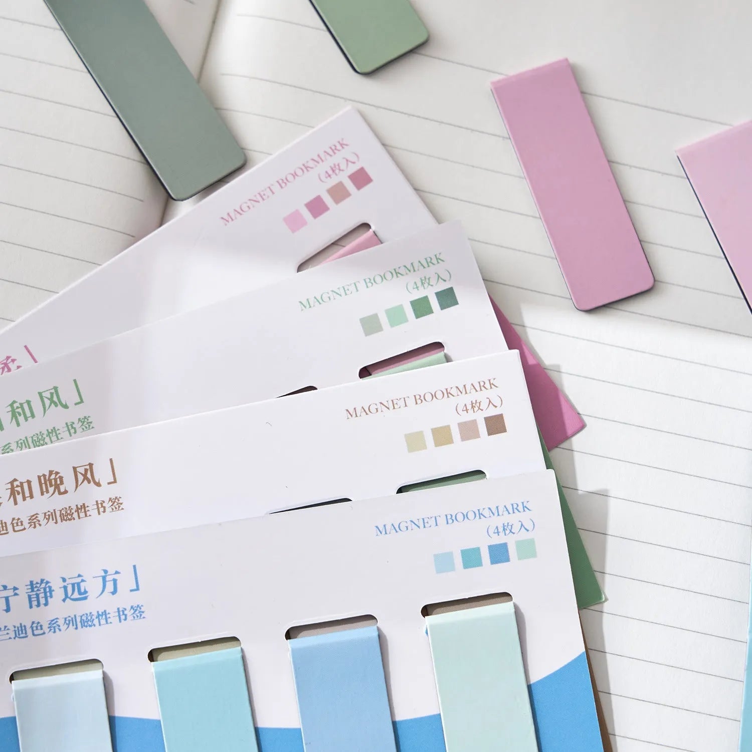Set of four pastel colour block magnetic bookmarks from the Morandi series on a book page.